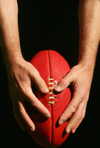 hands holding Australian football