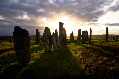 Ancient monument of standing stones cast shadows as sun rises